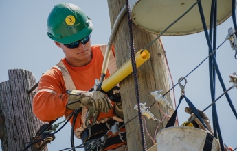 A young hydro worker makes repairs on a pole