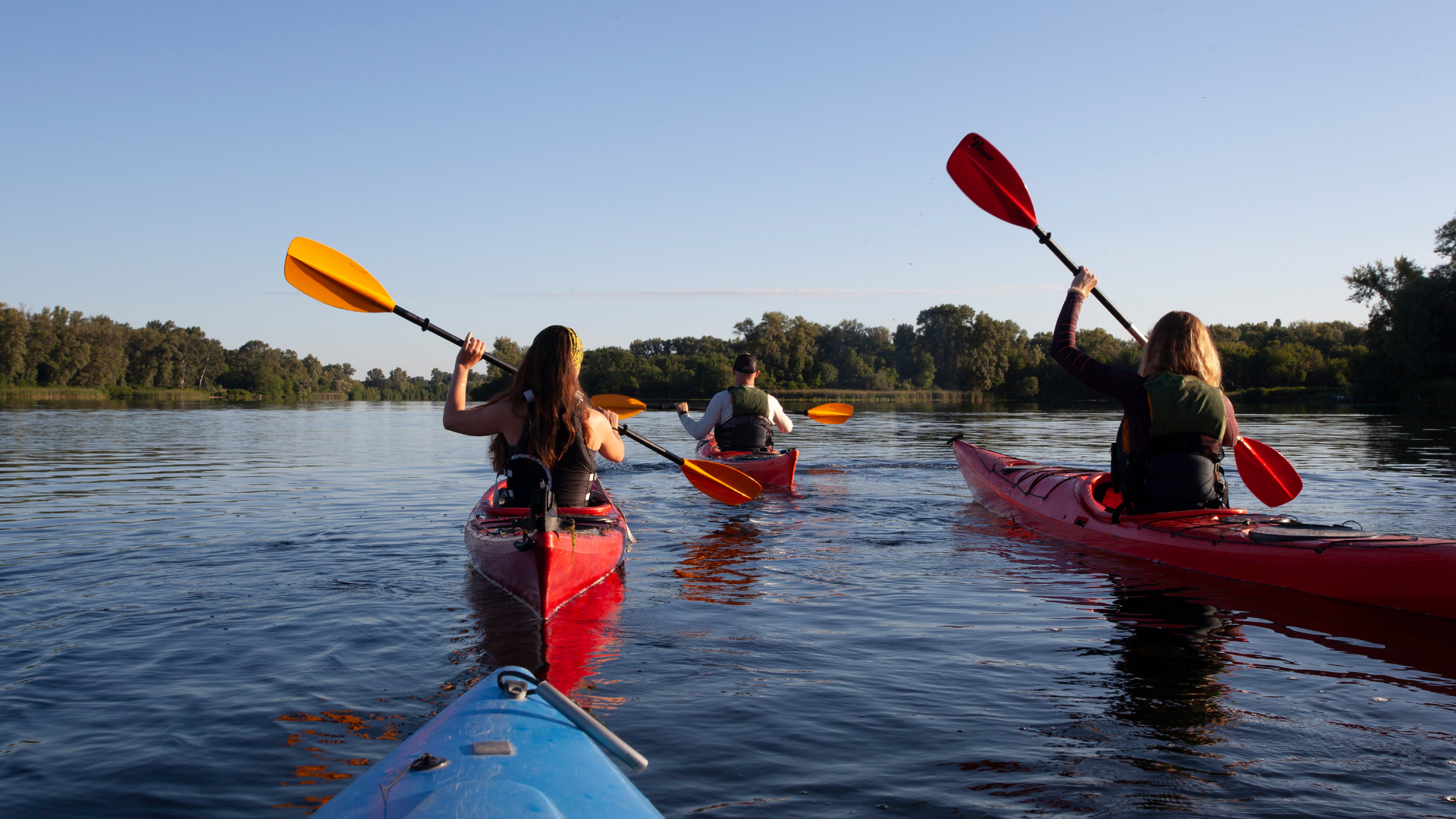 A group of friends kayaking with life jackets on