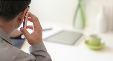 Man on cell phone in grey long-sleeve shirt