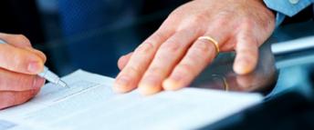 Close up of a man's hands as he signs a document