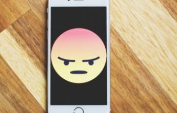 Cell phone with an unhappy face on the screen