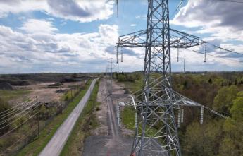 Transmission towers and distribution hydro poles run along a rural road in South-Nepean