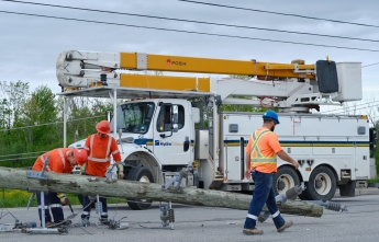 Hydro Ottawa crews attend to a downed hydro pole on May 22
