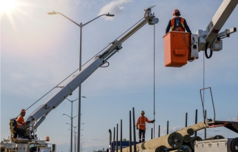 Hydro workers overseeing the arrival of new hydro poles