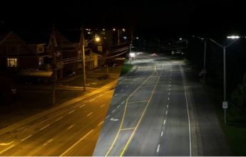 A before and after image of a street lit with old yellow-ish lighting and new brightly-lit LED lights