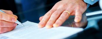 Close up of a man's hands as he signs a document