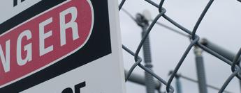 A warning sign on the surrounding fence of a Hydro Ottawa power station reads Danger. High Voltage.