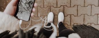 POV image of someone holding an iphone and looking down at their feet