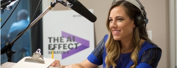 A woman sitting and talking in front of a microphone