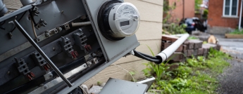 A broken meter lies on the ground beside a home