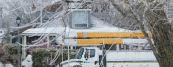 A Hydro Ottawa bucket truck in front of a house on a wintry day