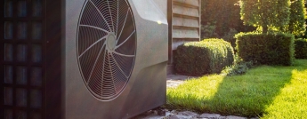 A heat pump in the backyard on a sunny day