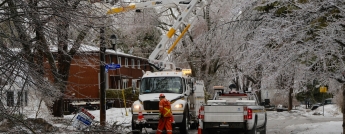 Hydro Ottawa crews work on an icy residential street during the 2023 Ice Storm